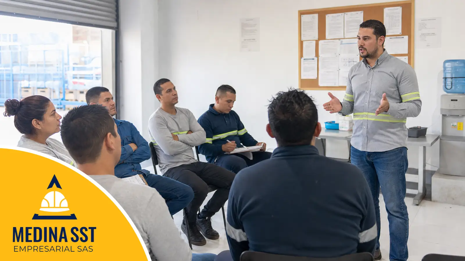 Las obligaciones del empleador se demuestran con evidencia Coordinador de seguridad y salud en el trabajo explicando responsabilidades a un grupo de trabajadores de una empresa colombiana durante una charla de cinco minutos