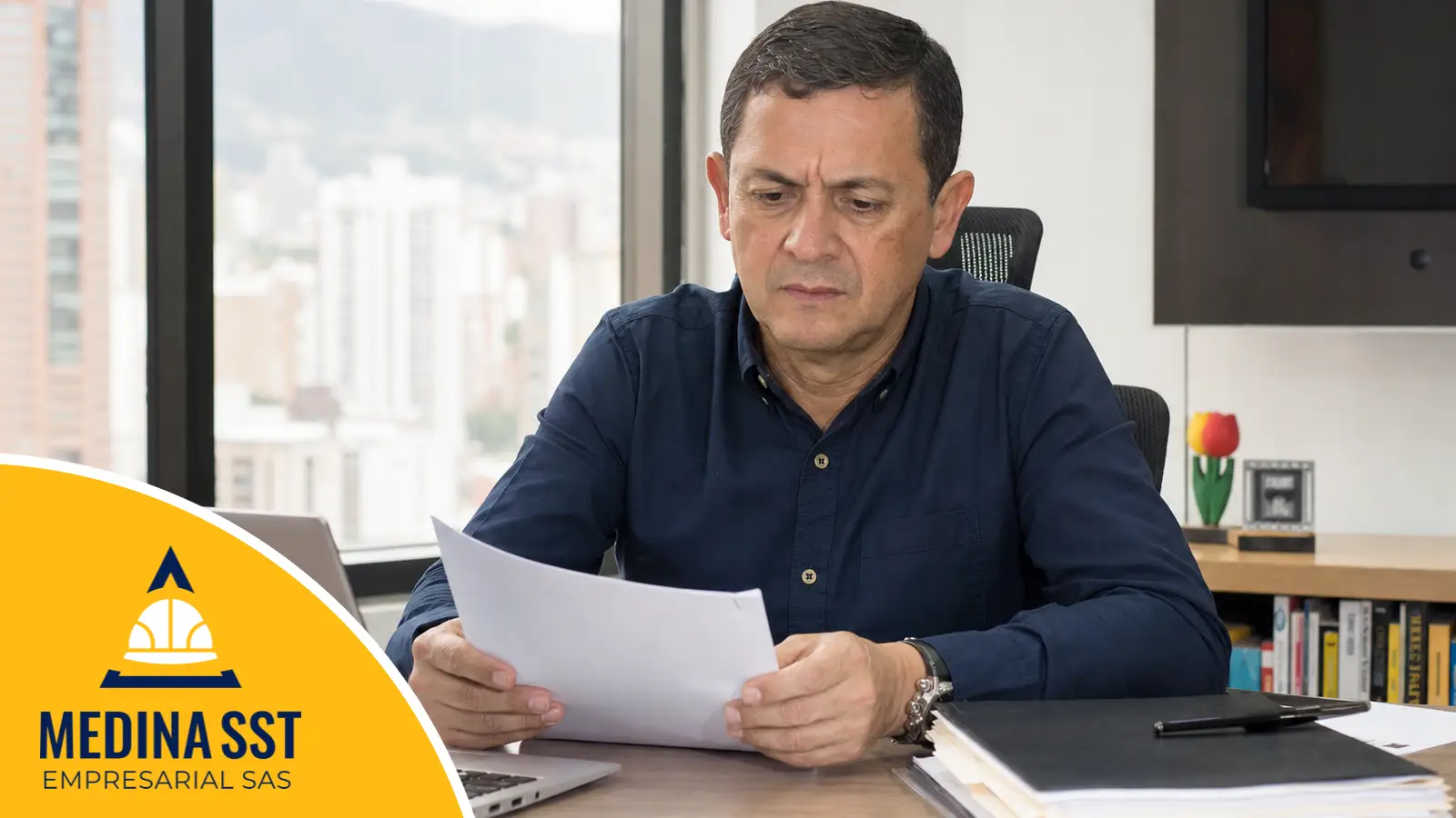 Qué régimen sancionatorio le aplica a cada incumplimiento Empresario colombiano leyendo en su oficina una comunicación oficial relacionada con el cumplimiento del SG-SST